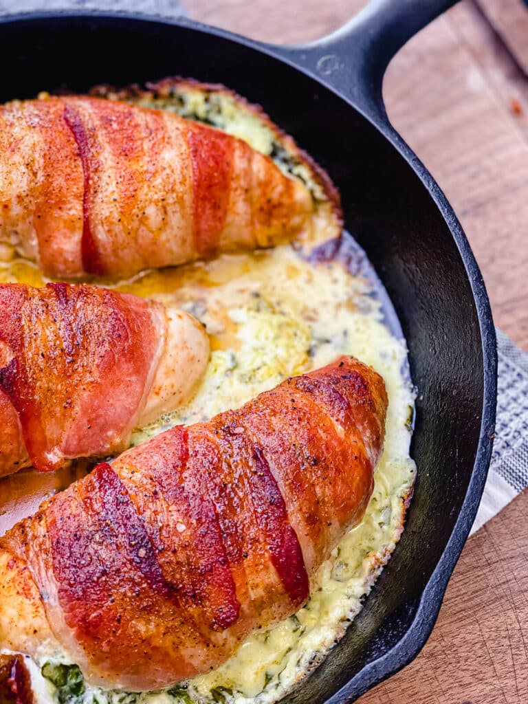 bacon wrapped stuffed chicken breast in a cast iron pan