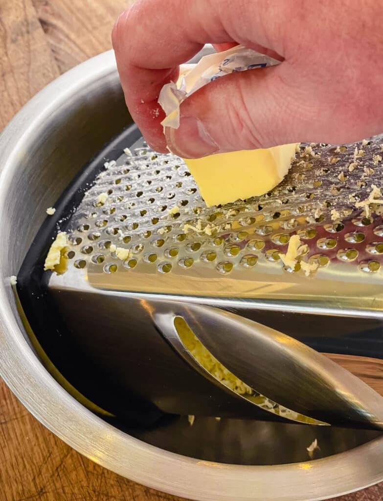 stick of butter being grated on a box grater