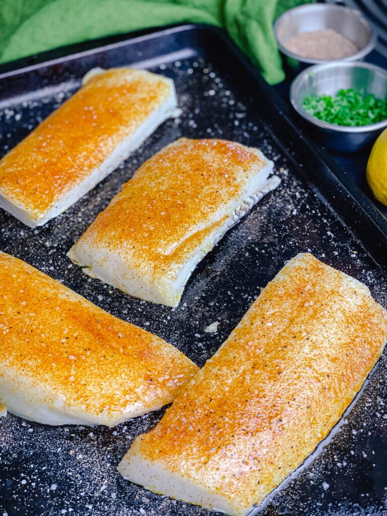 seasoned chilean sea bass on a baking sheet