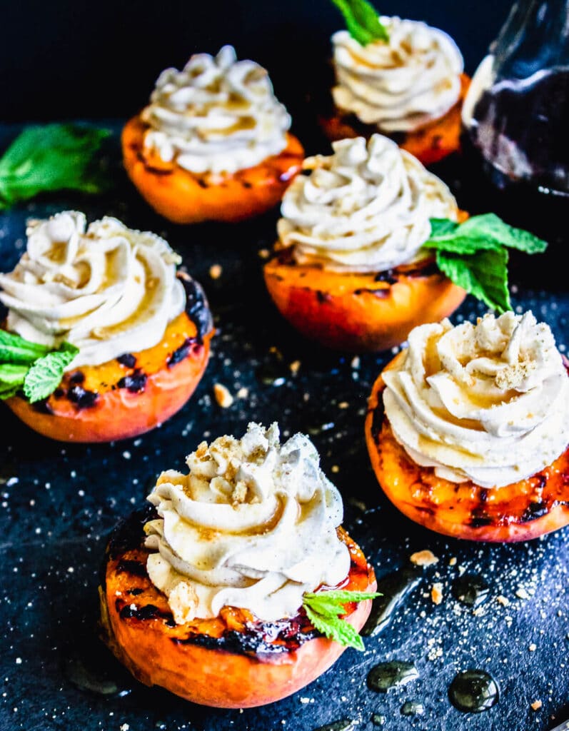 grilled peaches with mascarpone ice cream on a black cutting board