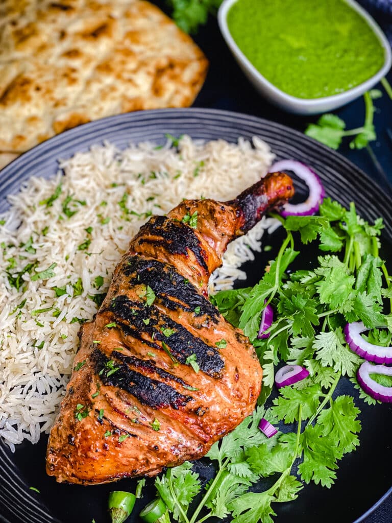 grilled tandoori chicken on a plate with rice