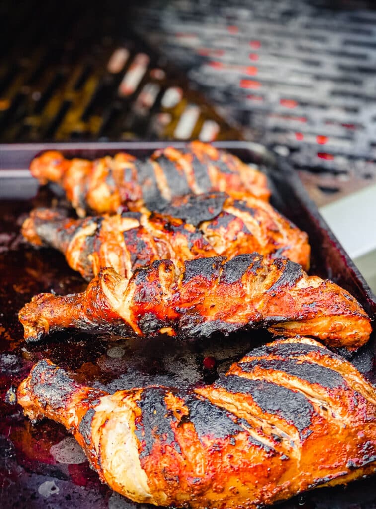 grilled chicken tandoori being removed from the grill