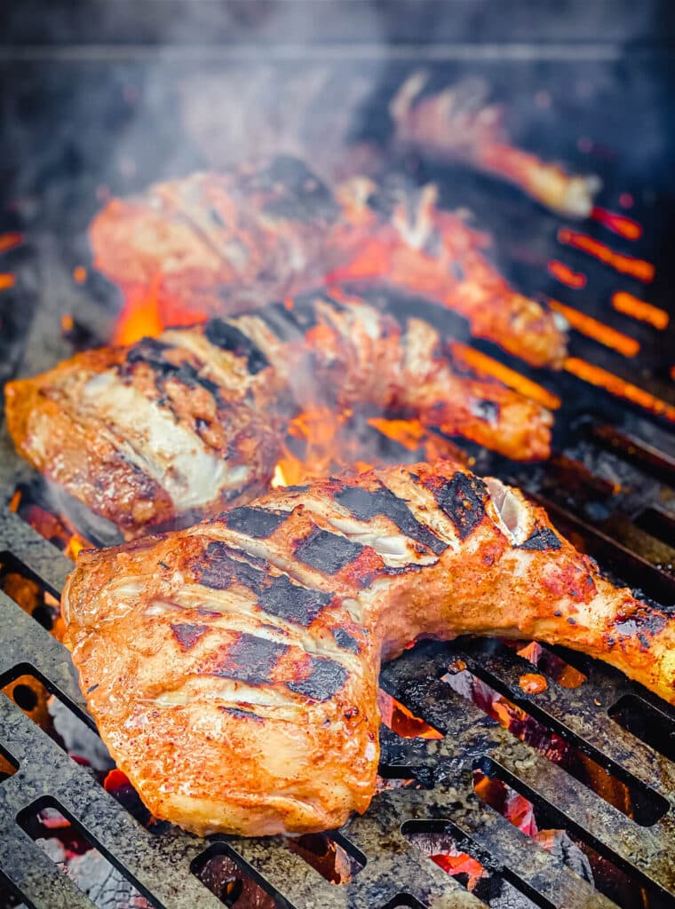 charred tandoori chicken on grill over flames
