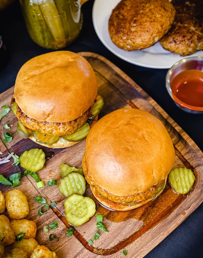 Nashville hot chicken burgers overhead photo with hot sauce and pickles