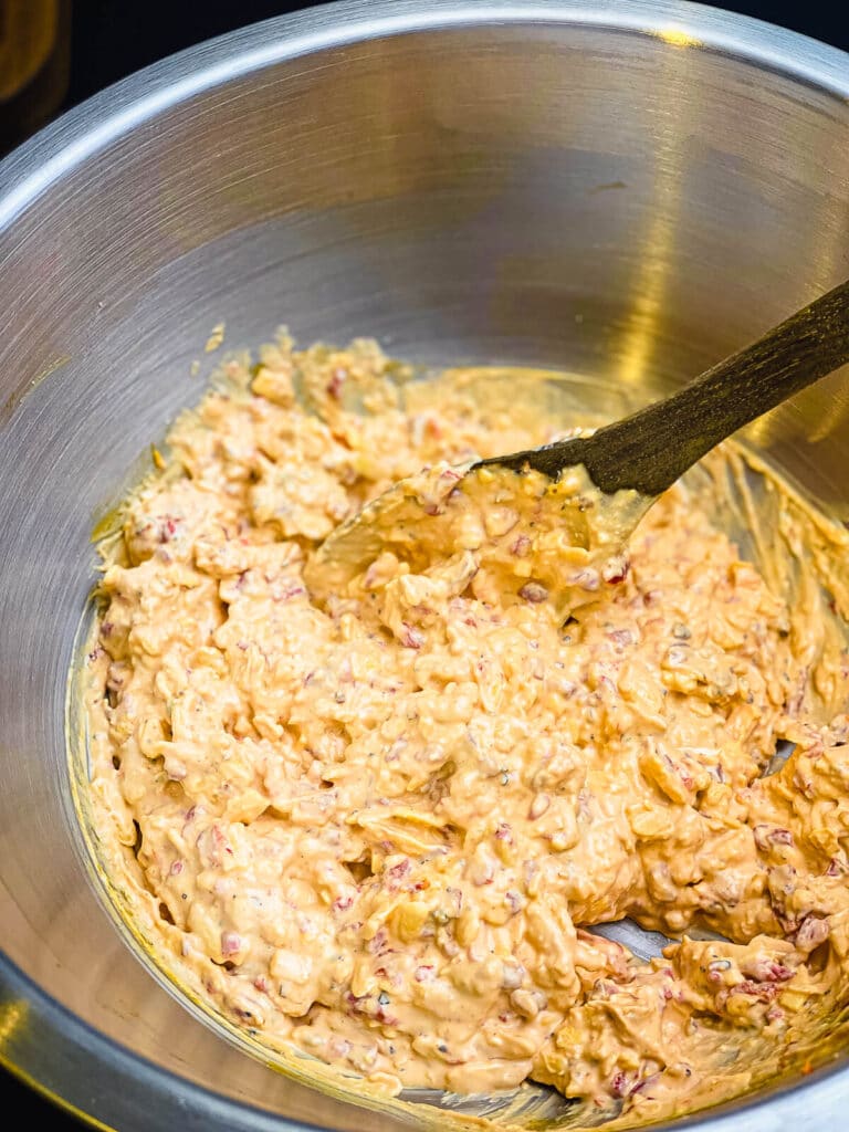 pimento cheese being mixed in a large mixing bowl