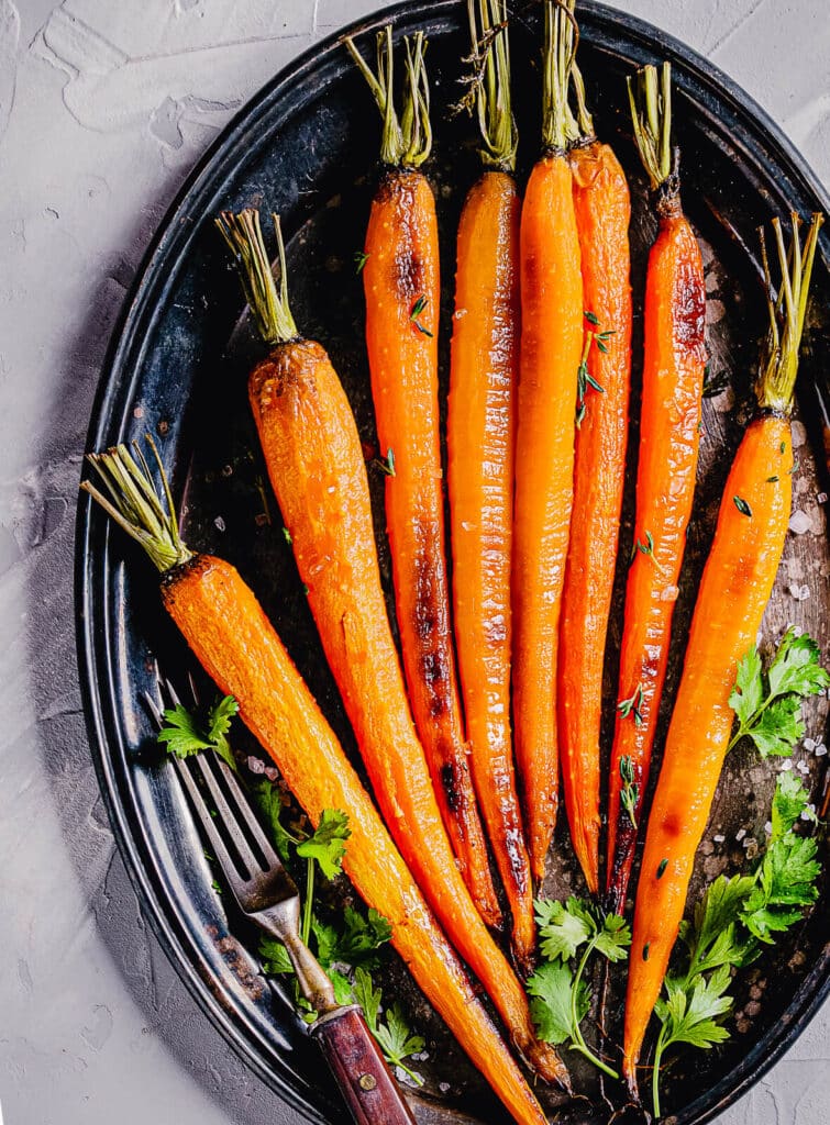 plate of roasted carrots with some greens