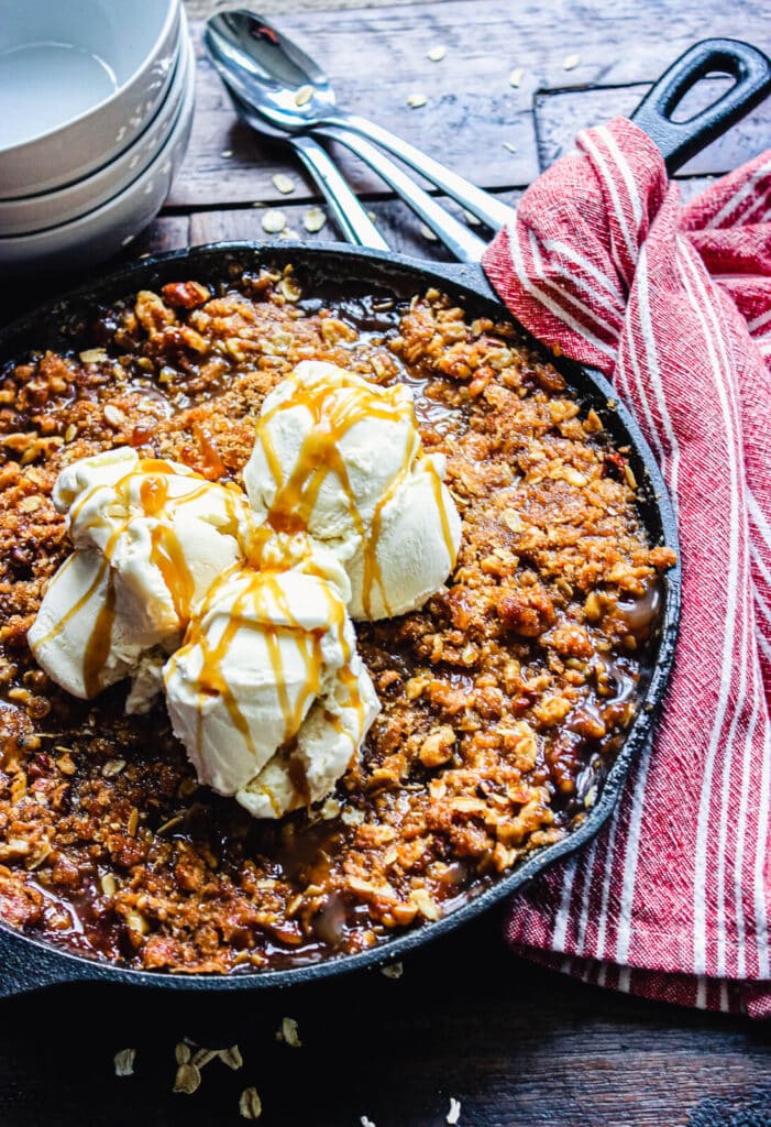 smoked apple crisp in a cast iron pan, topped with ice cream