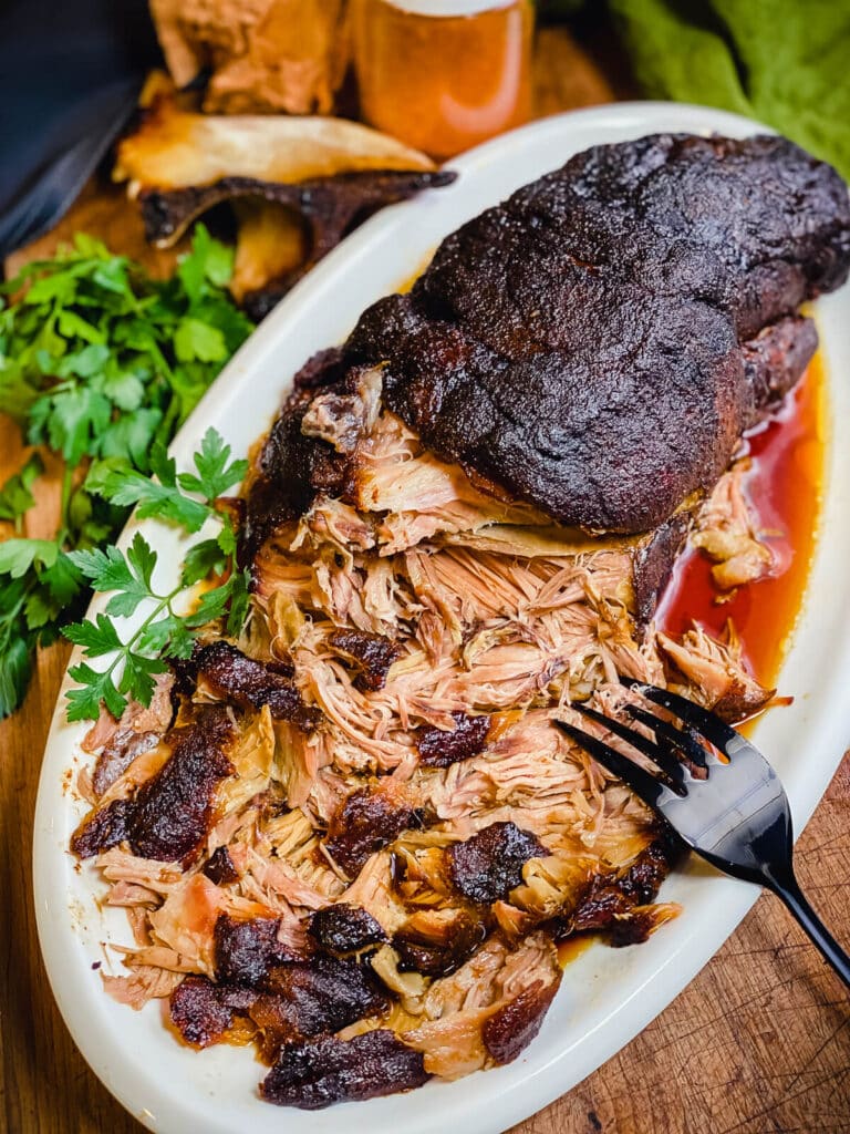 bbq pulled pork made in an oven on a white platter