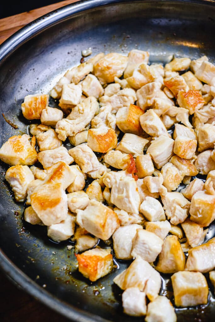 chicken breast pieces browned in a skillet