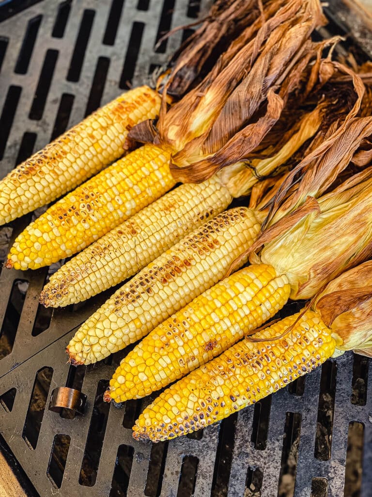 corn on the cob being grilled over hot coals
