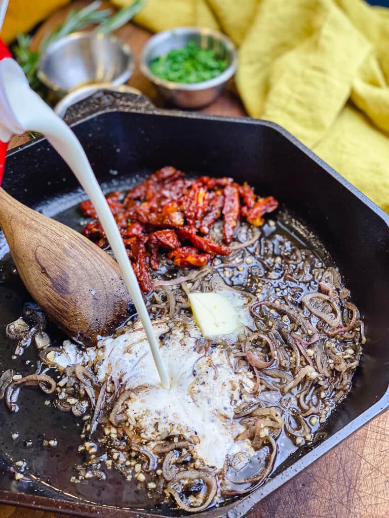 cream being added to pan seared pork chops sauce