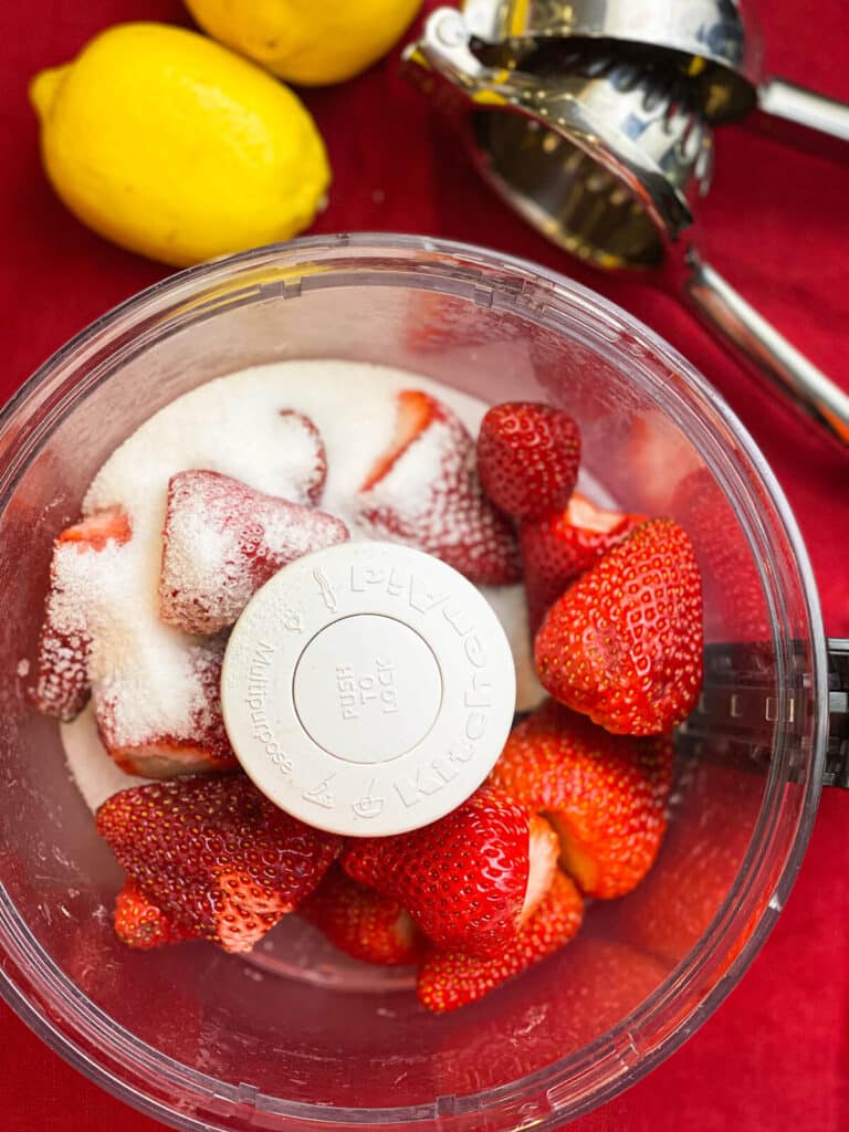 fresh strawberries and sugar in a food processor