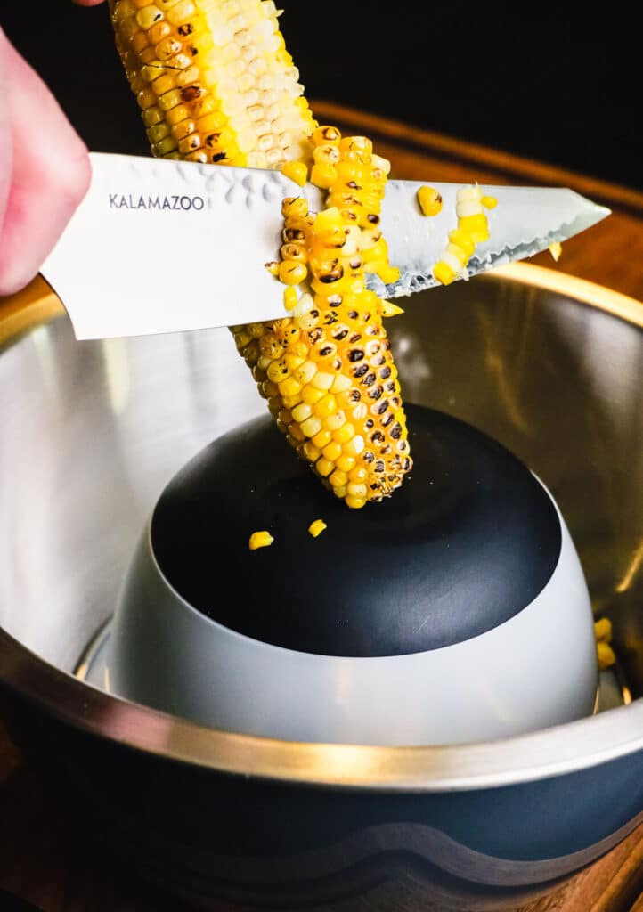 Mexican street corn being sliced off the cob
