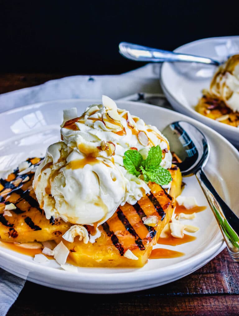 grilled pineapple with ice cream on a white plate