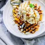 plate of grilled pineapple topped with ice cream