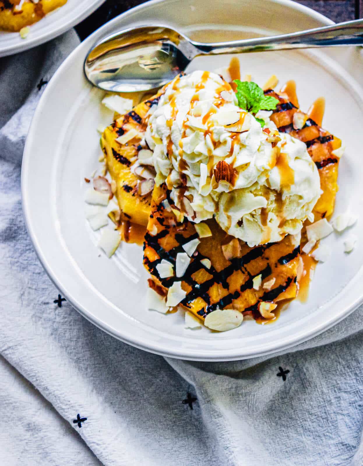 plate of grilled pineapple topped with ice cream