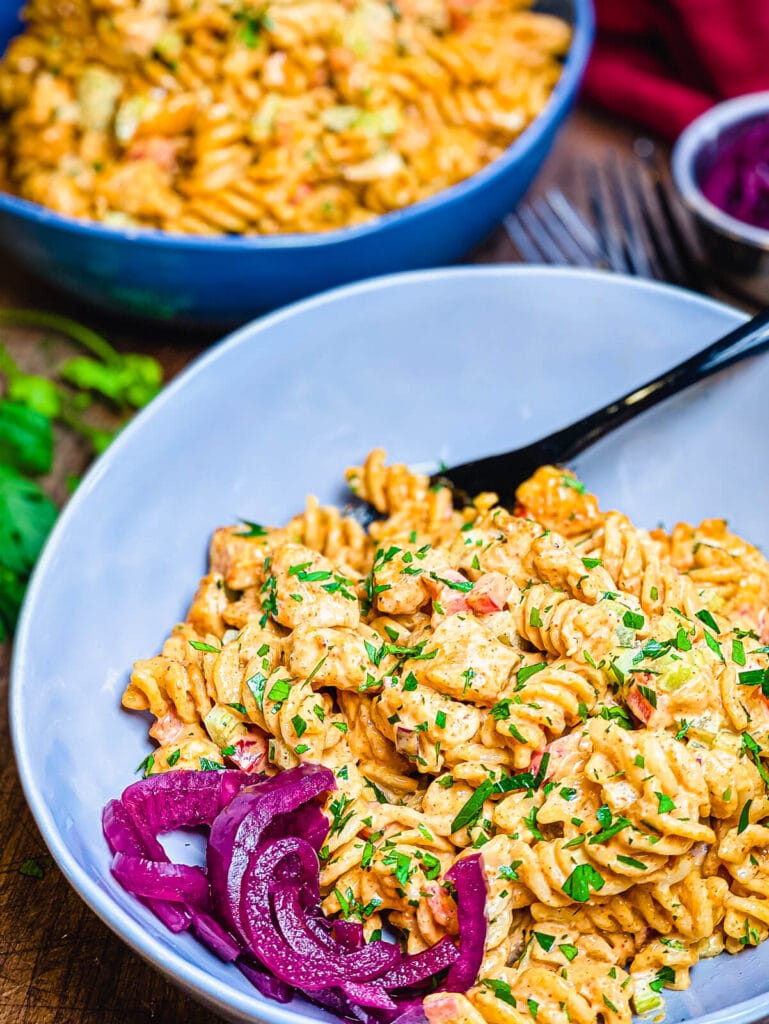 bowl of Nashville hot chicken pasta with pickled red onions