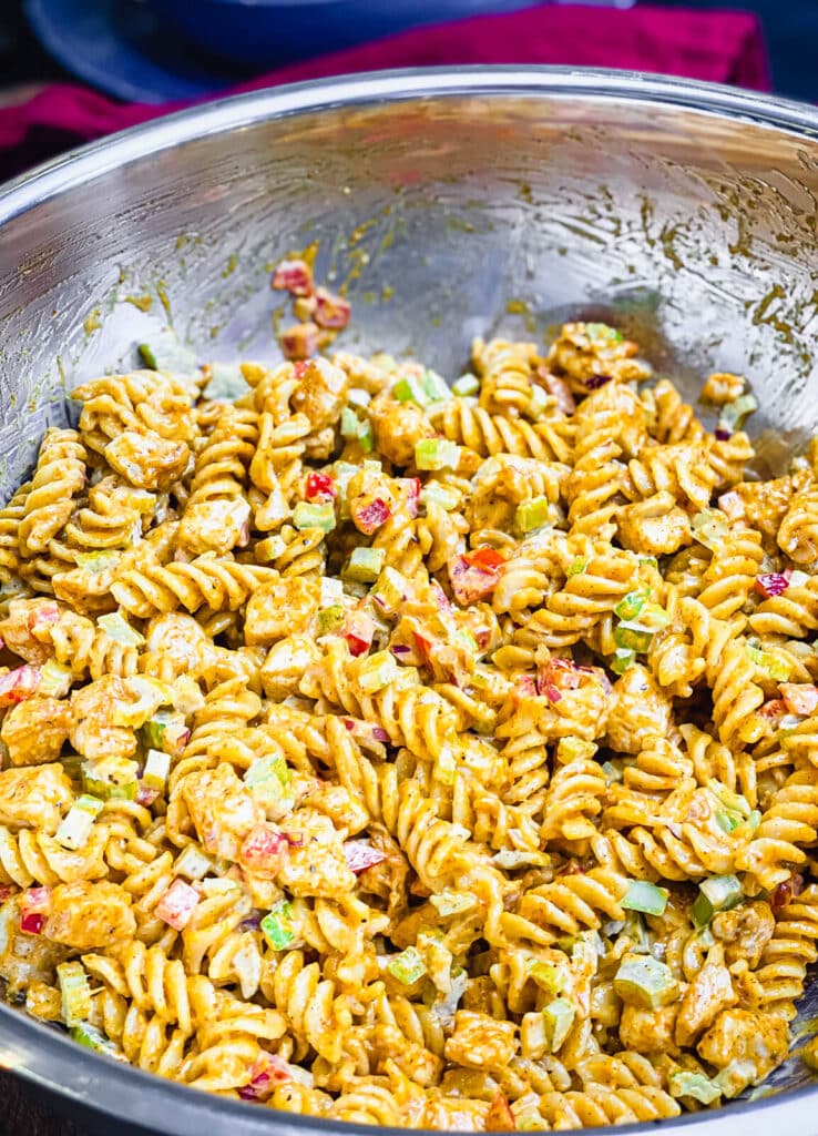 Nashville hot chicken pasta salad mixed together in a mixing bowl