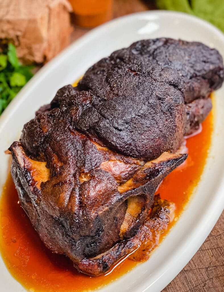 oven roasted pork shoulder on a white platter