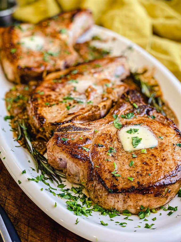 pan seared pork chops on a platter with a nice dark crust on the edge