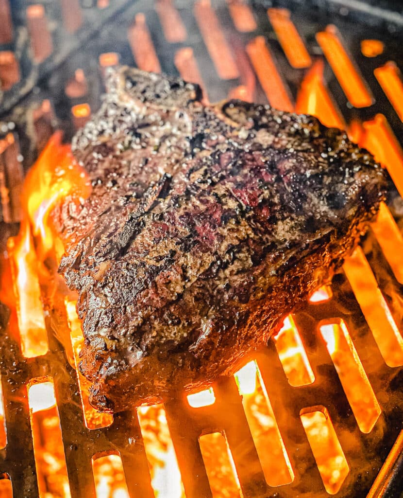 porterhouse steak grilling over fire