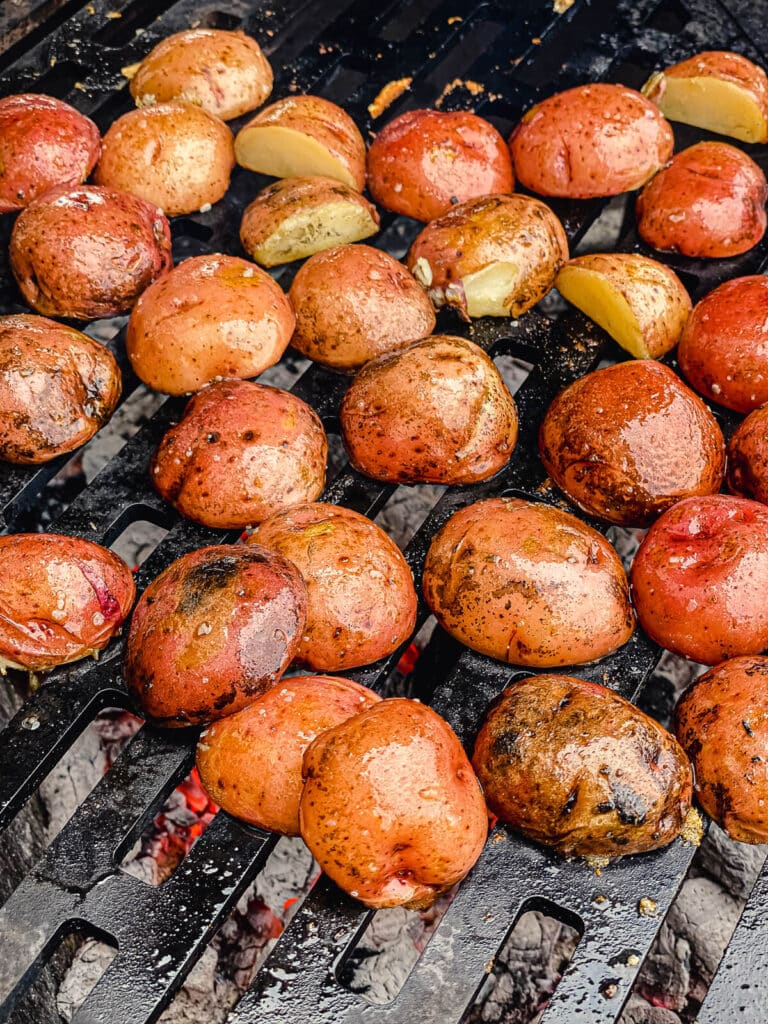 sliced potatoes on a grill grate over hot fire