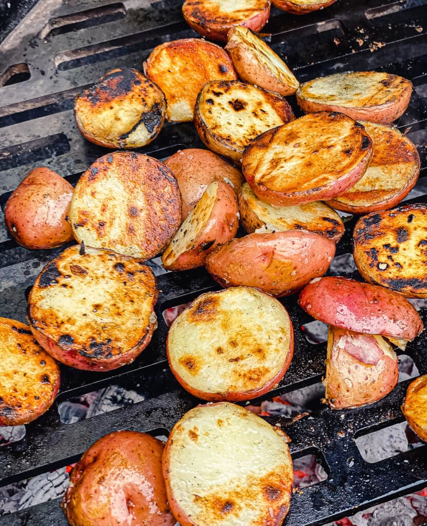 pile of grilled potatoes on a grill grate