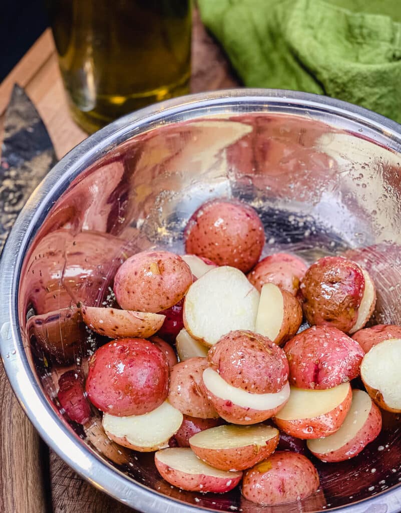 sliced potatoes for grilled potato salad in a mixing bowl