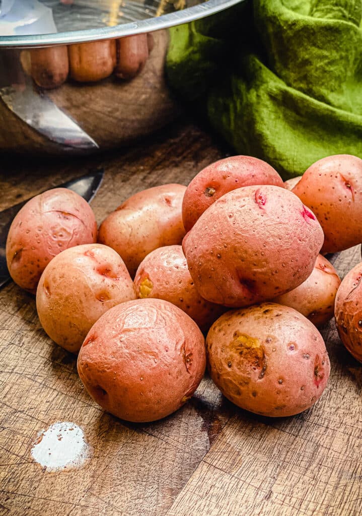 small red potatoes sitting on a cutting board
