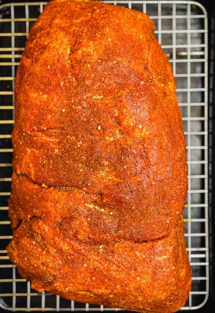 fulled seasoned pork butt on a wire rack