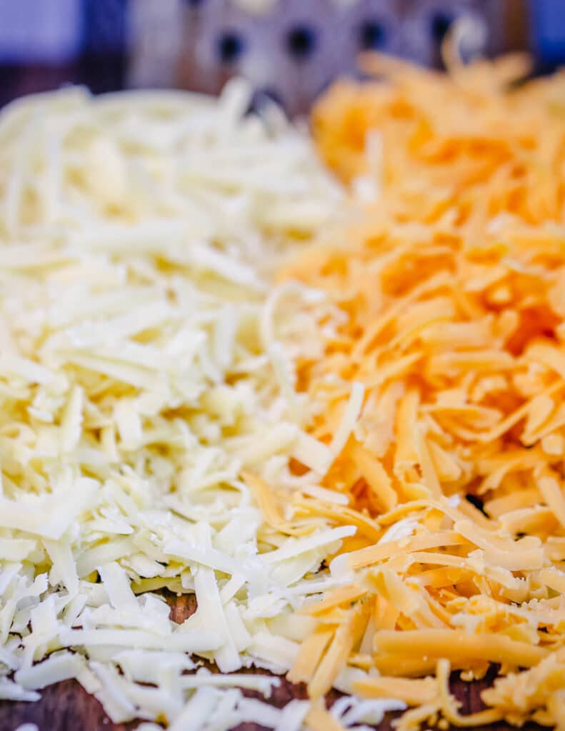 pile of shredded cheese on  a cutting baord