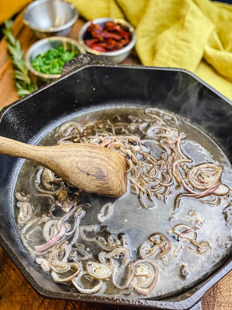 shallots cooked down in a cast iron pan for pan seared pork chops