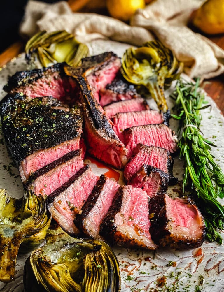 tuscan style porterhouse steak sliced on a platter