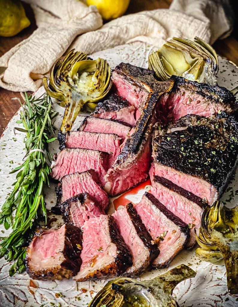 sliced porterhouse steak grilled tuscan style on a platter