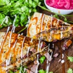 steak quesadilla on a cutting board drizzled with sour cream and bbq sauce