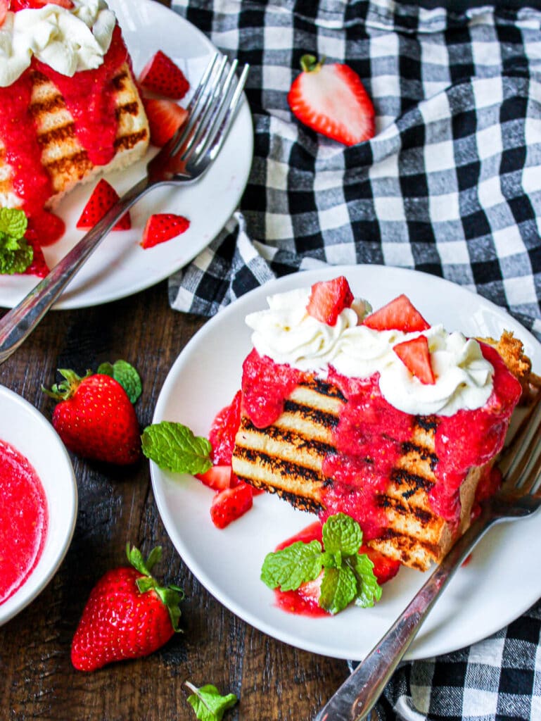 grilled angel food cake with strawberries on a table with whipped cream
