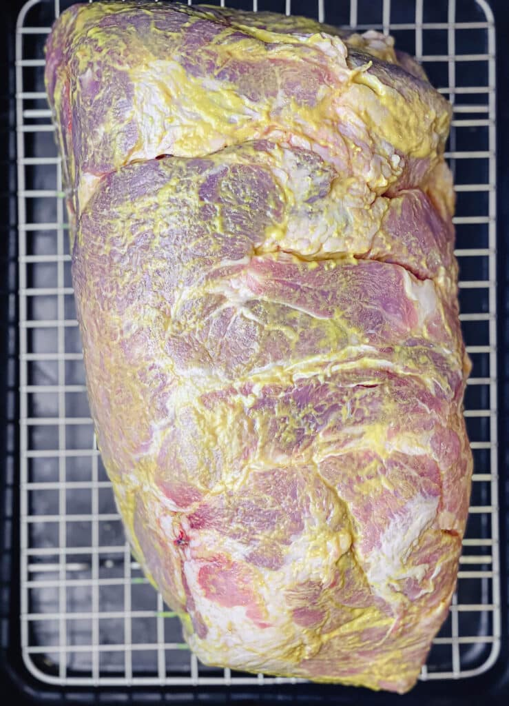 uncooked pork shoulder with a mustard binder