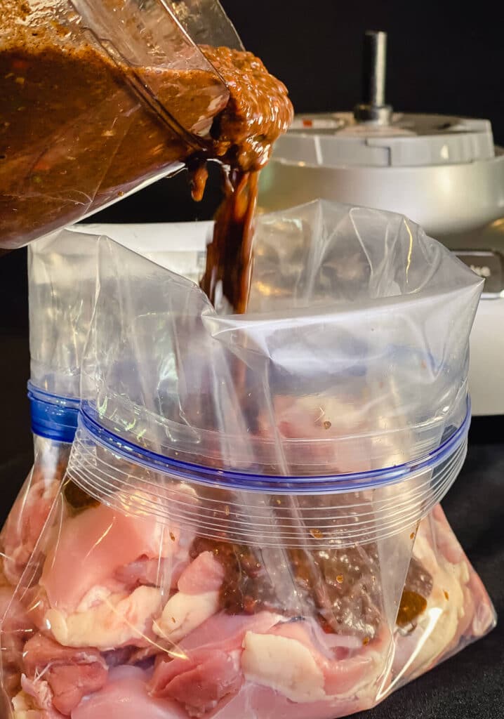 jerk marinade being poured over chicken in a plastic bag