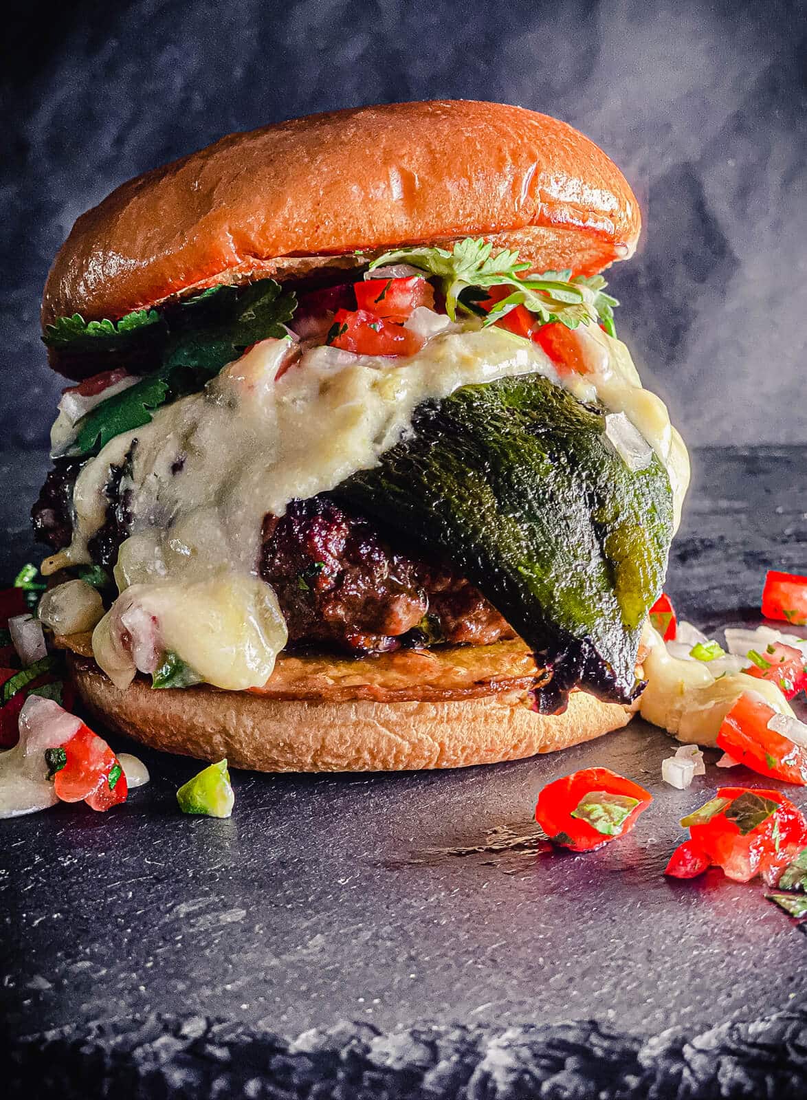 Mexican burger sitting on a black slate surface