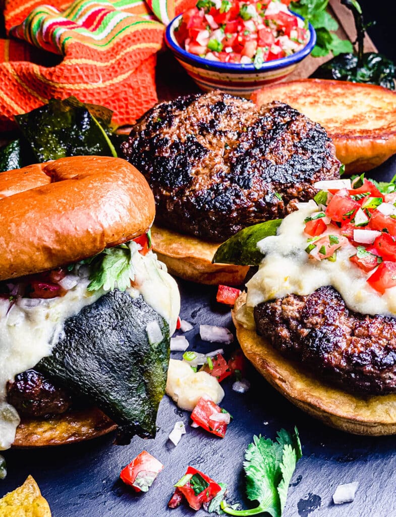 Mexican burgers on a platter with pico de gallo and poblano peppers