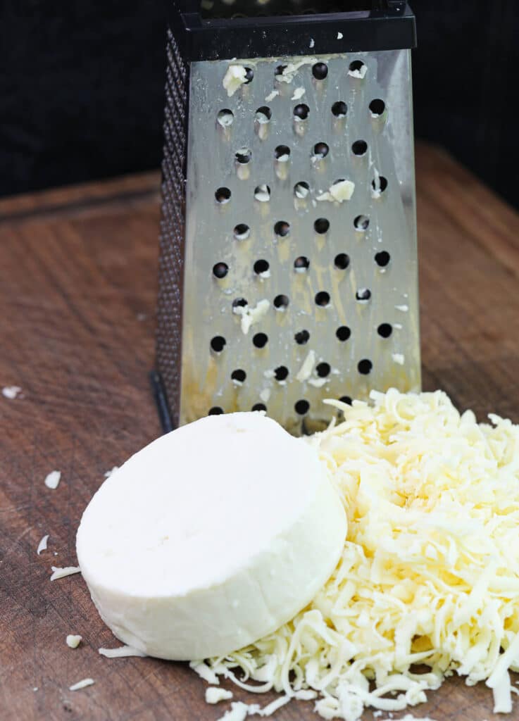 shredded cheese sitting next to a box grater