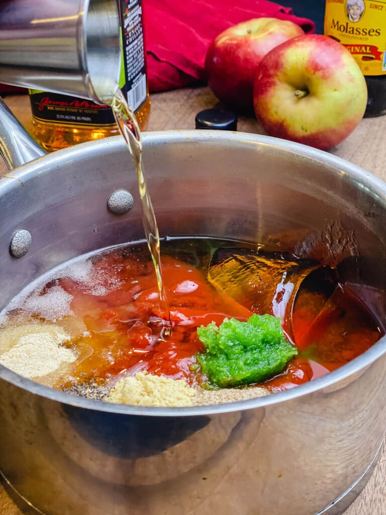 ingredients for apple whiskey bbq sauce in a saucepan