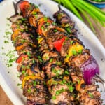 white platter with Jamaican jerk chicken skewers and green onions