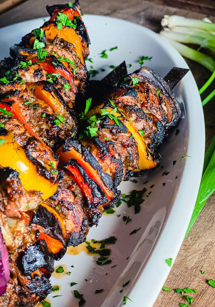 grilled chicken skewers on a white plate