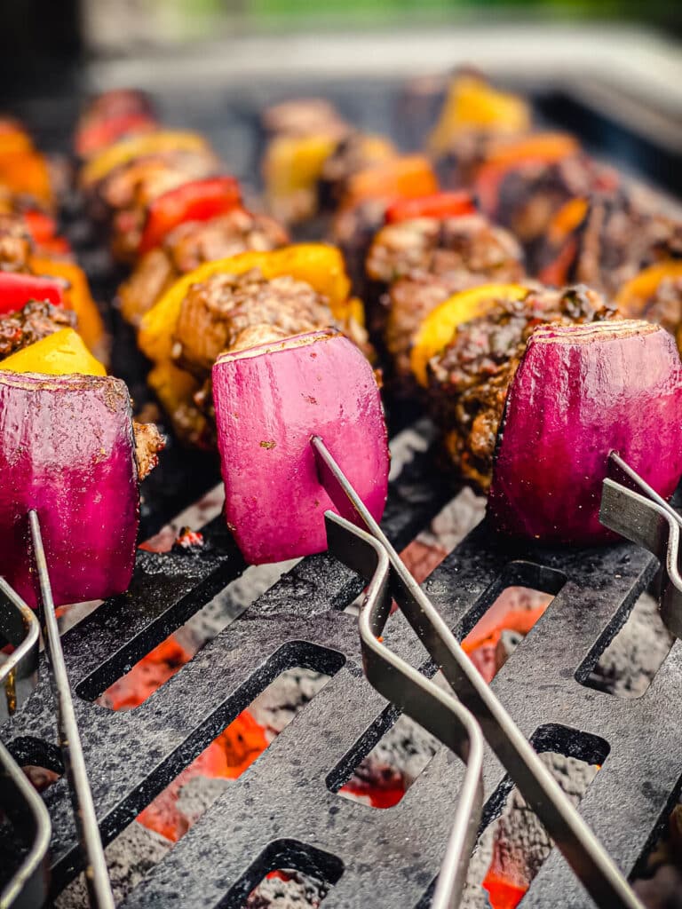 chicken skewers on a grill over direct heat