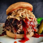 pulled pork sandwich topped with bbq sauce and crispy onions