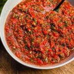 red chimichurri in a bowl with a spoon