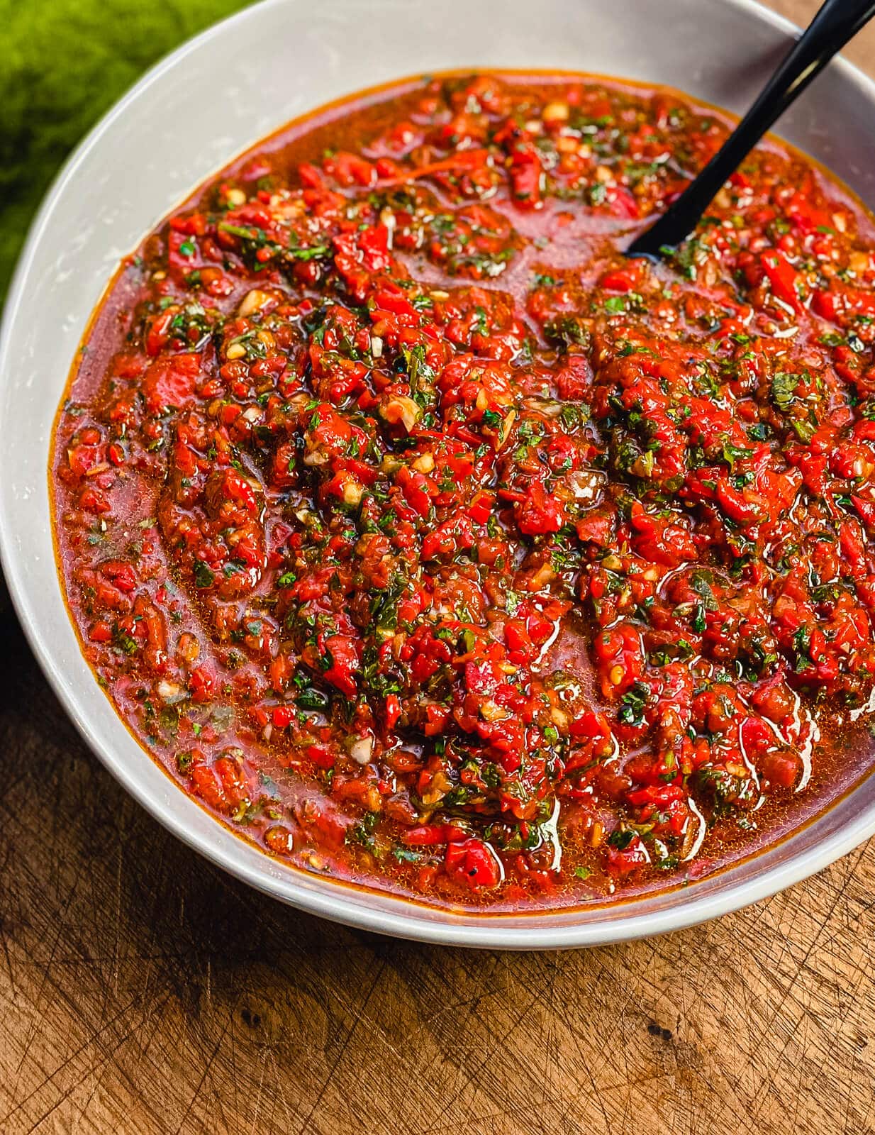 red chimichurri in a bowl with a spoon