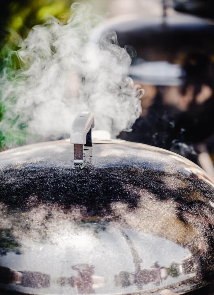 smoke coming from the lid of a bbq grill