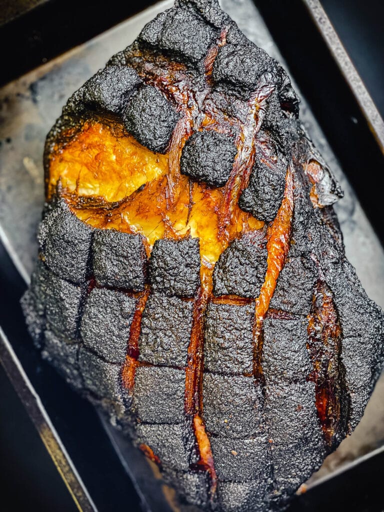 smoked pork butt with dark crust in a pan